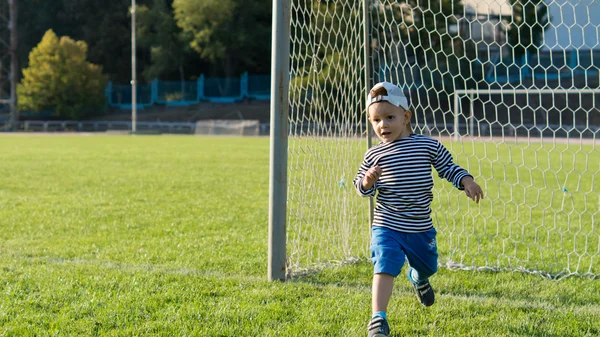 Petit garçon frappant un ballon de football — Photo