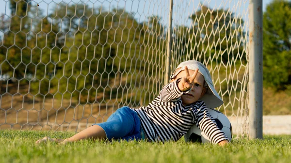 Μικρό αγόρι, κλωτσώντας μια μπάλα ποδοσφαίρου — Φωτογραφία Αρχείου