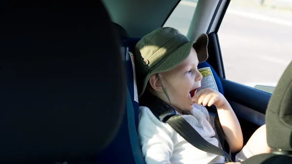 Bored little boy in a child seat — Stock Photo, Image