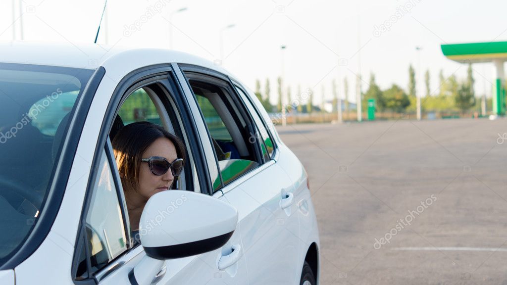 Female driver leaving a gas station
