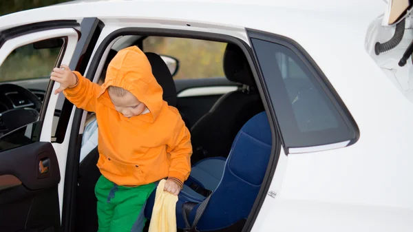 Liten pojke klättra ur en bil — Stockfoto