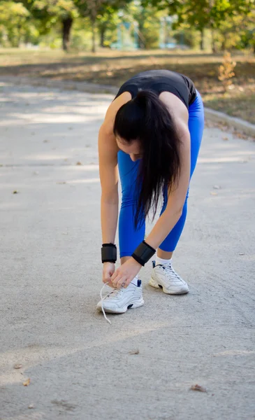 Woman athlete tying her shoelaces — Stock Photo, Image