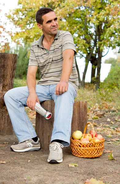 Człowiek siedzi na pniu — Zdjęcie stockowe