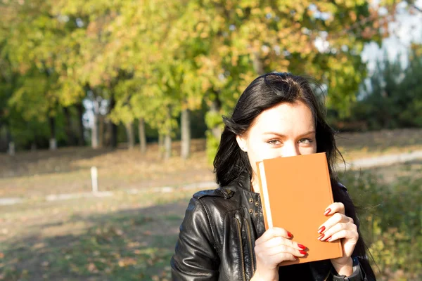 Woman hiding behind book — Stock Photo, Image