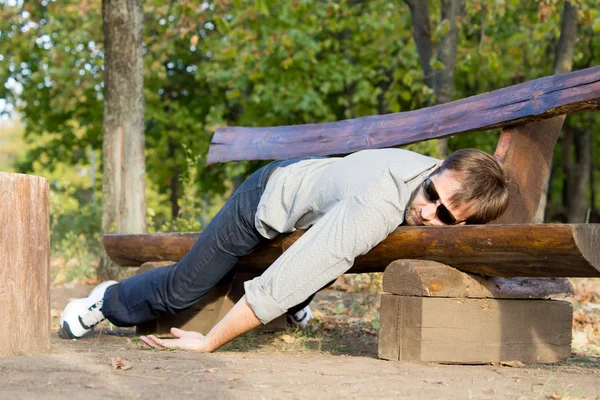 Uomo esausto che dorme sulla panchina — Foto Stock