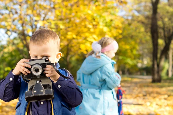 Malý chlapec hraje s retro fotoaparát — Stock fotografie