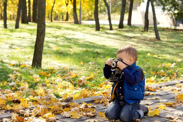 Menino pequeno usando uma câmera slr vintage — Fotografia de Stock