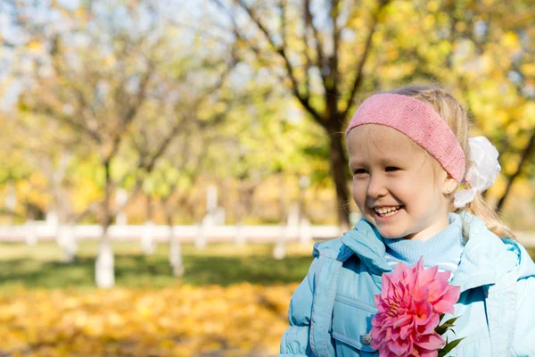 Usměvavá holčička s růžovými dahlia — Stock fotografie