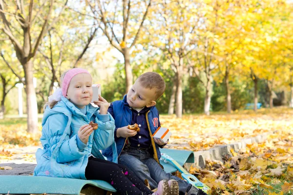 Kinder bei einem Imbiss im herbstlichen Ambiente — Stockfoto