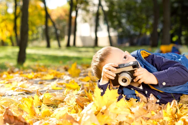 Piccolo ragazzo che gioca con una fotocamera slr — Foto Stock