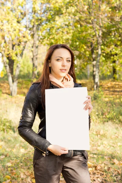 Woman holding a blank sign in woodland — Stock Photo, Image