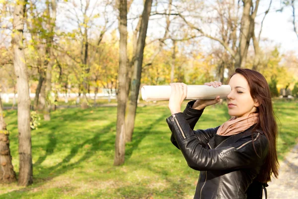 Femme utilisant un journal roulé comme verre espion — Photo