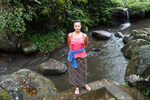 Attractive woman standing above a stream — Stock Photo, Image