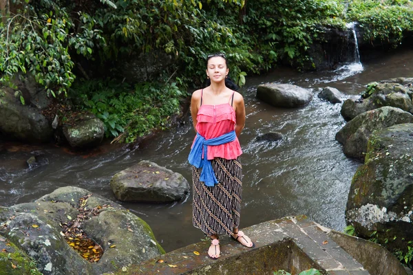 Attractive woman standing above a river — Stock Photo, Image