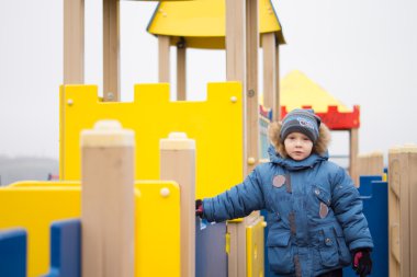 Kışın bir oyun parkında oynayan çocuk