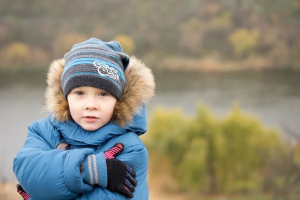 Lindo niño frío abrazándose a sí mismo — Foto de Stock