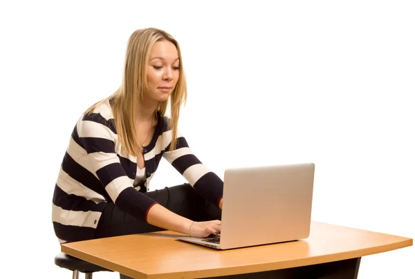 Κομψό νεαρή γυναίκα που εργάζεται σε ένα φορητό υπολογιστή — Φωτογραφία Αρχείου