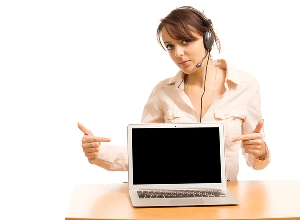 Mujer con auriculares apuntando a su portátil — Foto de Stock