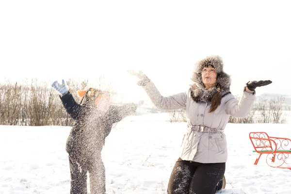Moeder en kind spelen in de sneeuw — Stockfoto