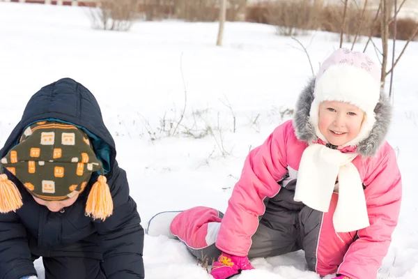 Twee jonge kinderen spelen in sneeuw — Stockfoto