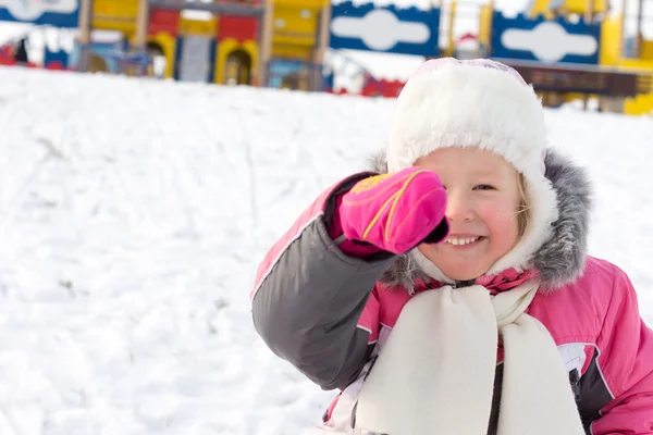 Little girl laughing in a snowy playground — Stock Photo, Image