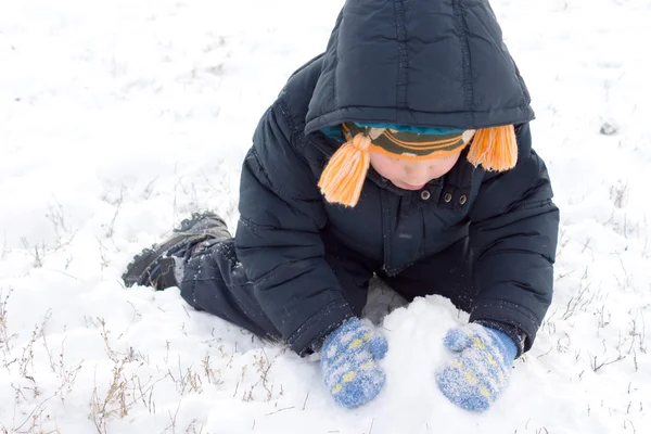 Liten pojke samla upp snö — Stockfoto