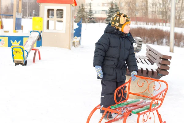 小男孩与他的雪橇在冬天的雪 — 图库照片