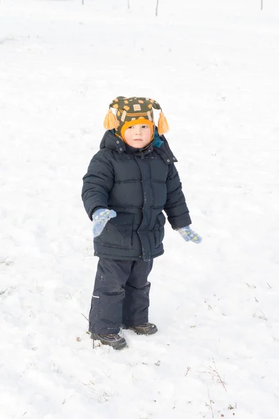 Adorable little boy standing in snow — Stock Photo, Image