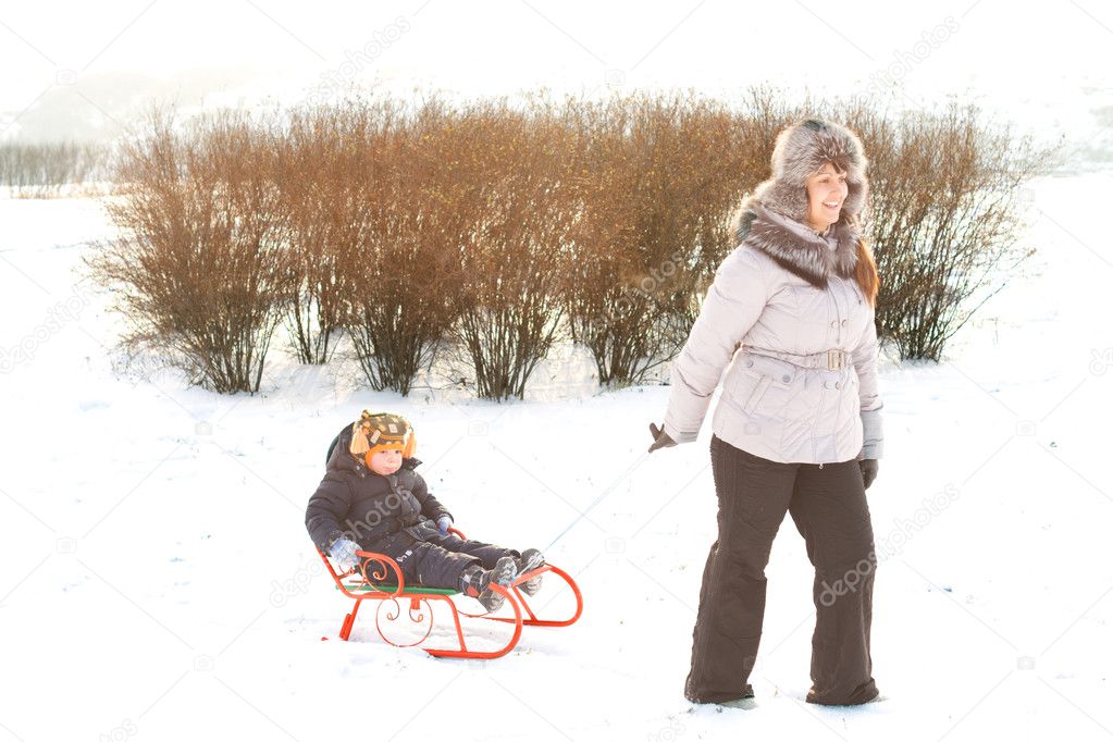 Little boy riding on a sled