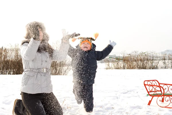 母亲和儿子在雪中嬉戏 — 图库照片