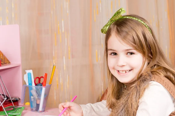 Glückliches kleines Mädchen an ihrem Schreibtisch — Stockfoto