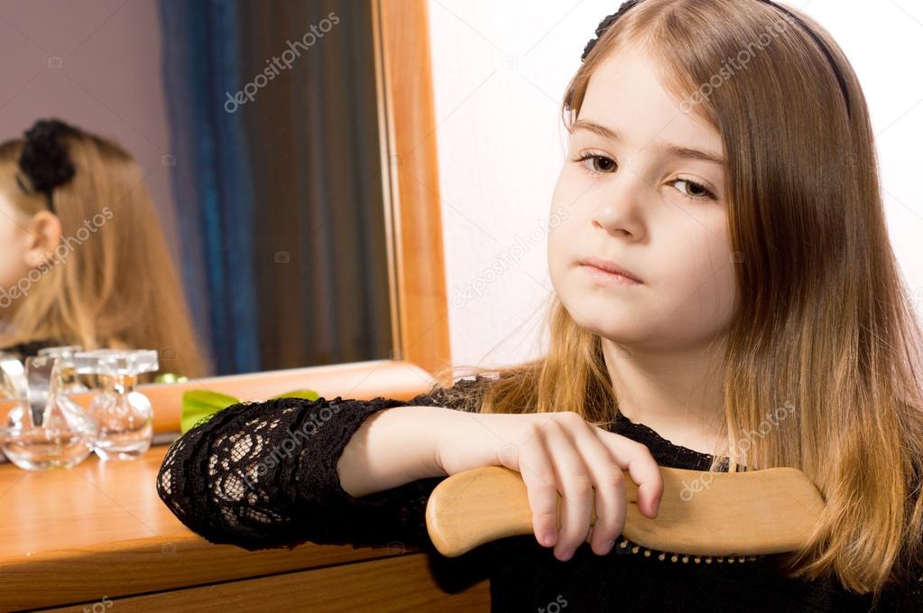 Sad little girl brushing her hair