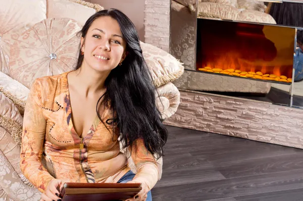 Ler vacker kvinna framför en eld — Stockfoto