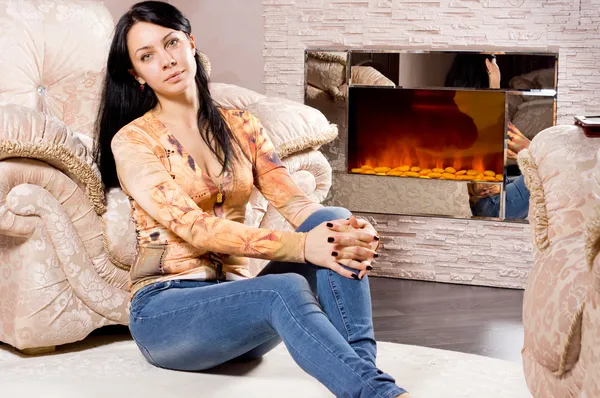 Mulher relaxante na frente de um fogo quente — Fotografia de Stock