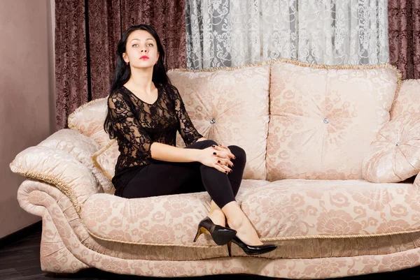 Sophisticated woman posing on a sofa — Stock Photo, Image