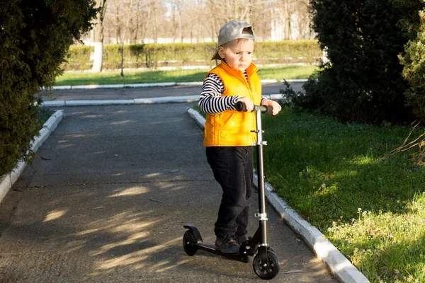 Genç çocuk bir scooter sürme — Stok fotoğraf