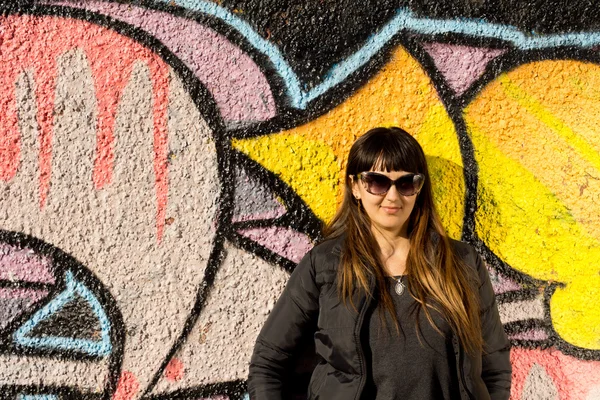 Atraktivní žena pózuje před graffiti — Stock fotografie