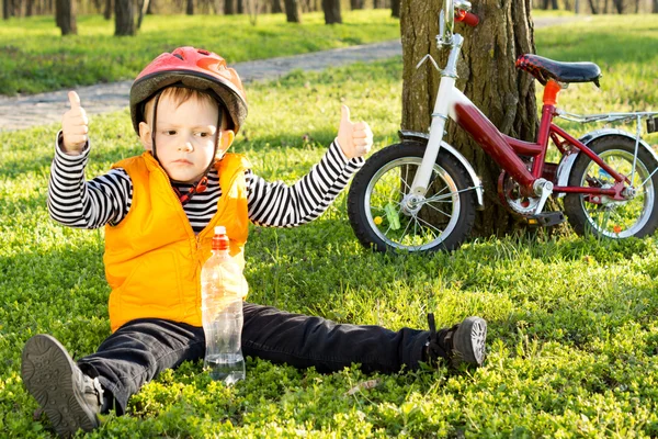 Piccolo ragazzo in sella dando un pollice in su — Foto Stock