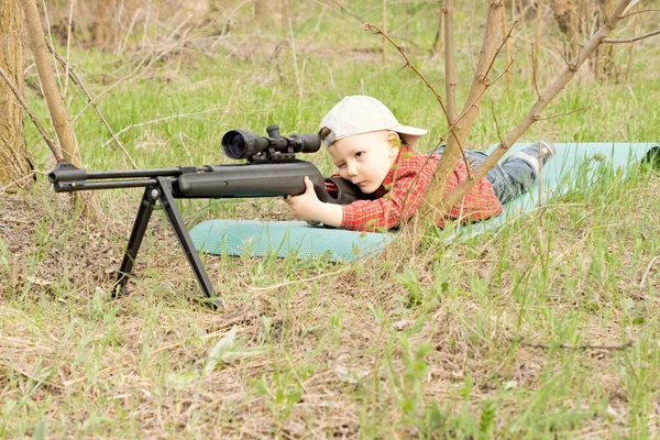 Mały chłopiec, biorąc celem z karabinem — Zdjęcie stockowe