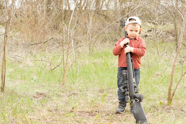 Little boy holding a rifle over his shoulder — Stock Photo, Image