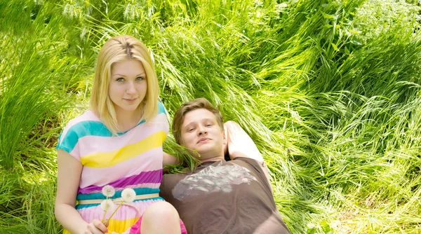 Portret van een jong koppel liggen op het gras — Stockfoto