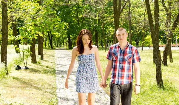 Jovem casal caminhando juntos em um parque — Fotografia de Stock