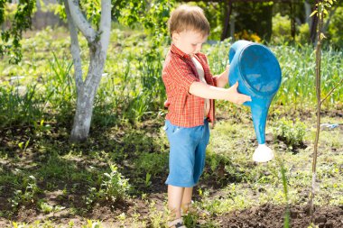 A cute kid watering a plant with watering can clipart