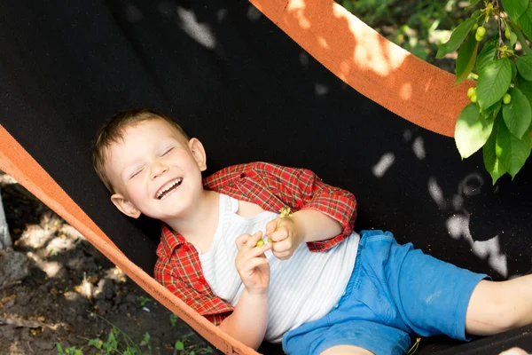 Laughing little boy in a hammock — Stockfoto