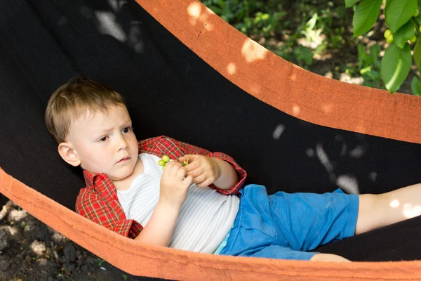 A cute kid lying on the swing — Stockfoto