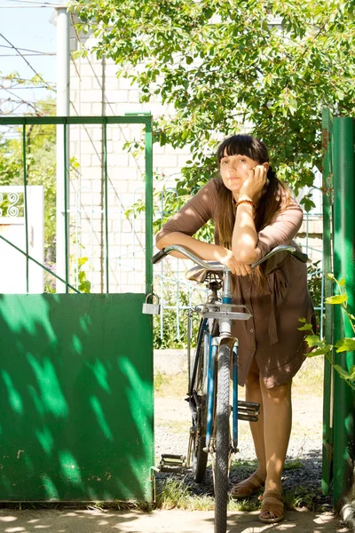 Nachdenkliche Frau mit ihrem Fahrrad — Stockfoto