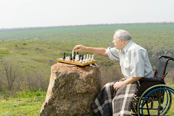 Älterer Mann im Rollstuhl spielt Schach — Stockfoto