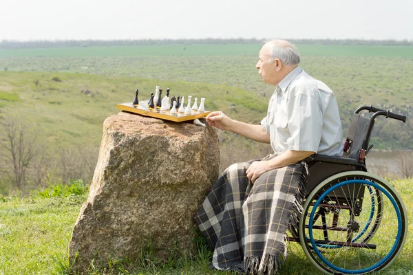 Handicapped pensioner playing chess outdoors — Stock Photo, Image