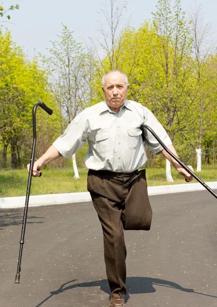 Elderly disabled man balancing on one leg — Stock Photo, Image