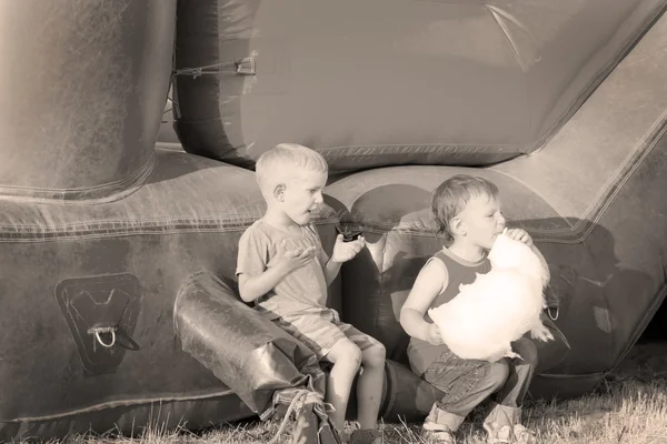 Dois meninos comendo algodão-doce perto de um slide — Fotografia de Stock